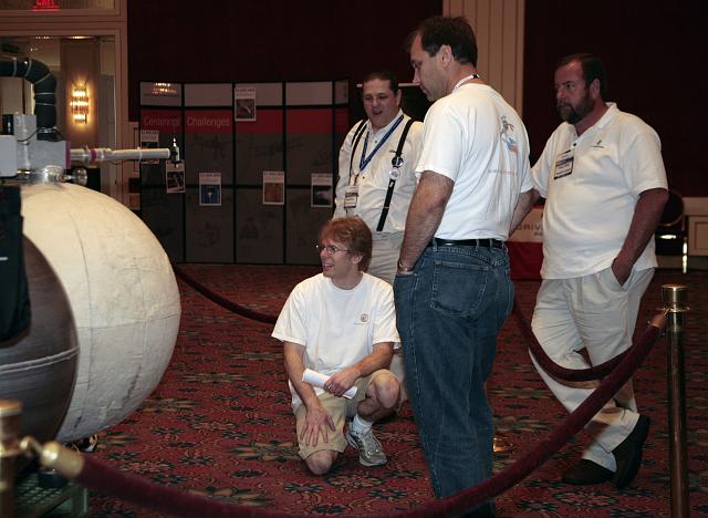 Armadillo Aerospace CEO John Carmack (kneeling) confers with Armadillo Aersopace team members Phil Eaton (center) and Tommy Bishop (R) at the International Space Development Conference