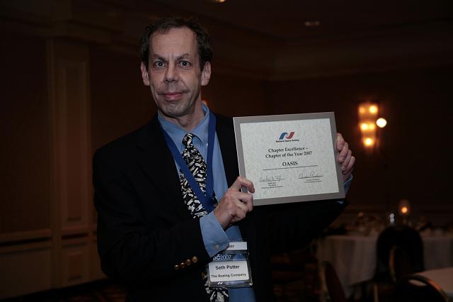 Seth Potter of the NSS OASIS chapter holds the NSS Chapter Excellence: Chapter of the Year 2007 Award presented to the OASIS chapter at the International Space Development Conference